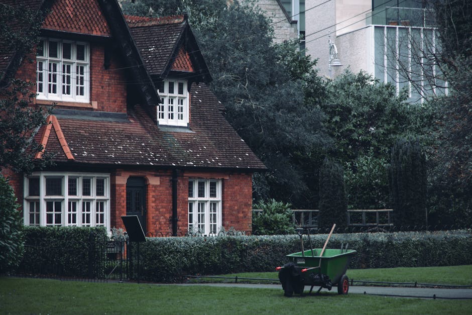 Image of a traditional brick residential building with multiple large white-framed sash windows and a bay window on the ground floor. The building has a slate roof with chimney stacks and several smal
